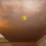 This image shows the protective cap projecting below the surface of a newly plastered ceiling